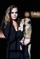 Model Cara Delevingne walks the runway with a lion as she joins TAG Heuer as Brand Ambassador to launch the new 2015 campaign at Palais des Beaux-Arts on January 23, 2015 in Paris, France.